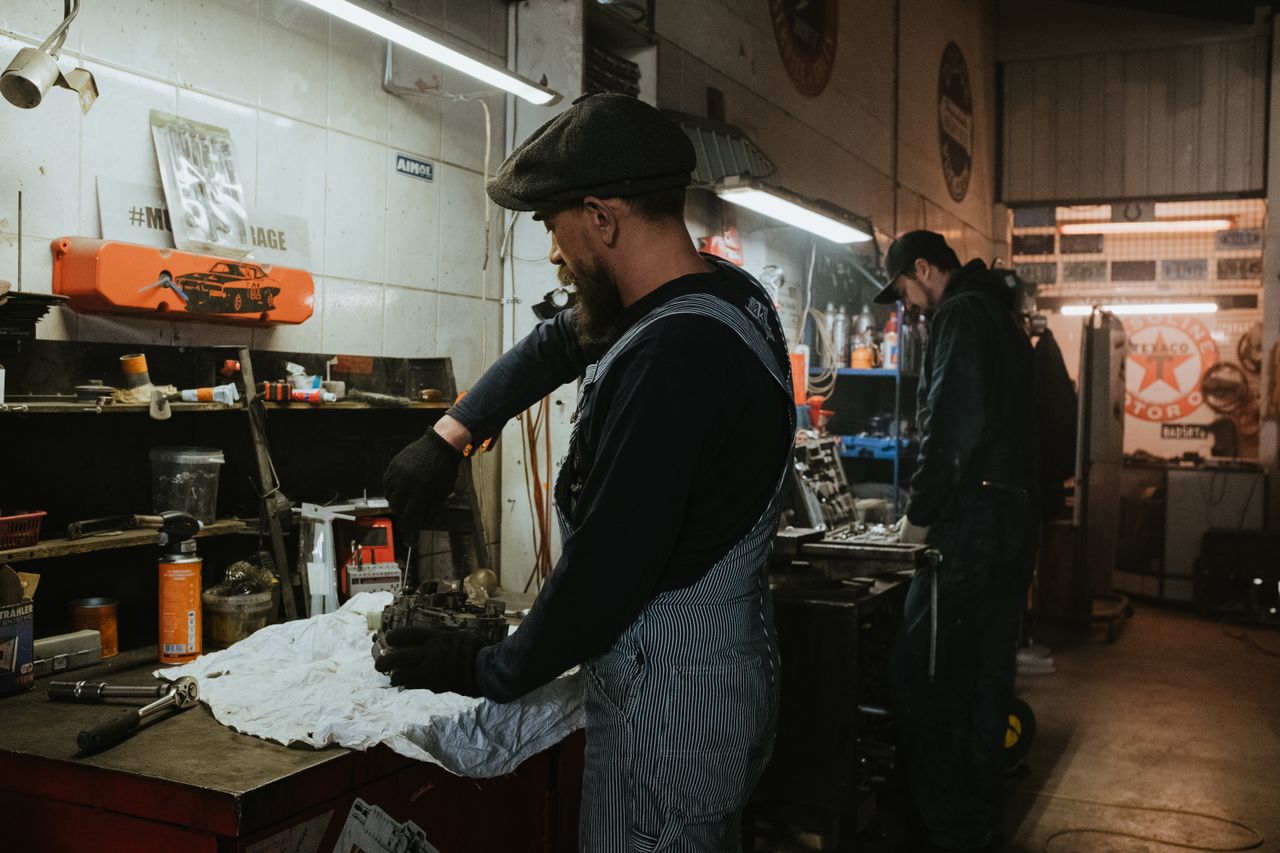 Mechanic using a pneumatic impact wrench for automotive repairs